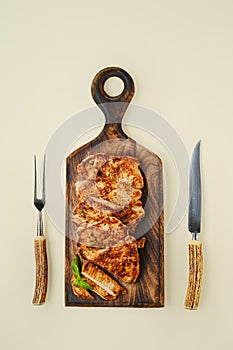 Top view of fried chopped pork tenderloin on wooden cutting board