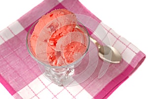 Overhead view of a glass of cherry sherbet on a red and white na