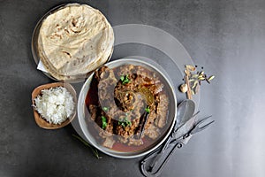 Overhead view of Goat curry, Mutton curry, Nihari, Rogan Josh in a bowl with Chapati and plain Rice photo