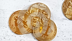 Overhead view, golden commemorative btc - bitcoin cryptocurrency - coins scattered on white stone board, closeup detail