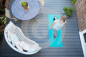 Overhead View Of Healthy Mature Woman At Home Exercising On Deck  With Dumbbell Hand Weights