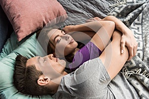 overhead view of heterosexual couple hugging and sleeping