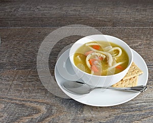 Overhead view of homemade chicken noodle soup with spoon and who