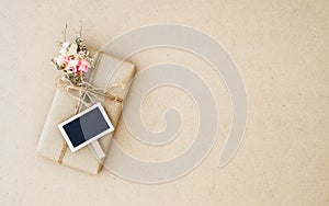 Overhead view homemade DIY wrapped  present boxes with mini blank space chalkboard on brown wood background with copy space for