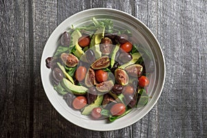 Overhead view of a large bowl of fresh salad on wood