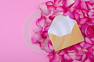Overhead view of letter and envelope on flower petals isolated on pink background, copy space