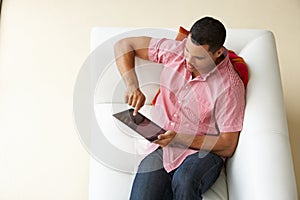 Overhead View Of Man Relaxing On Sofa Watching Television