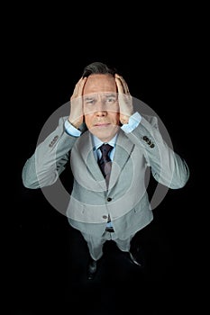Overhead view of middle aged frightened businessman in suit