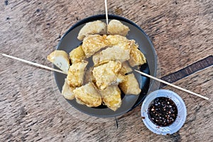 Overhead view of pisang goreng or banana fritters with dip sauce, unique traditional delicacy in Southern Malaysia in