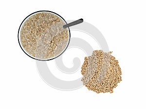Overhead view of porridge in bowl next to pile of uncoocked grain