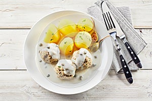 Overhead view of potatoes and meatballs with sauce photo