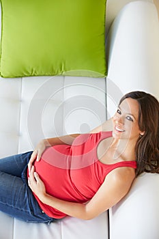 Overhead View Of Pregnant Woman Relaxing On Sofa