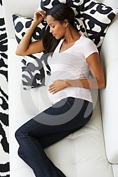 Overhead View Of Pregnant Woman Sleeping On Sofa