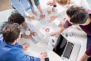 Overhead view of professional businesspeople discussing and brainstorming together on workplace in office