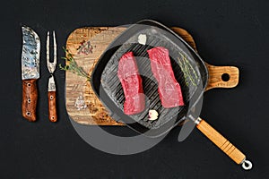 Overhead view of raw boneless beef loin steak on cast iron skillet
