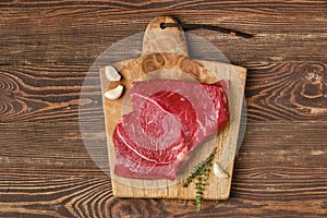 Overhead view of raw top side beef steak on wooden tabletop