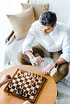 Overhead view of retired men playing chess