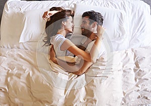 Overhead View Of Romantic Couple Lying In Bed Together photo
