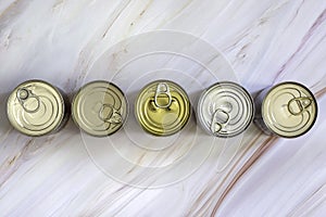 Overhead view row canned food in different sizes and colors. Stock preserved food