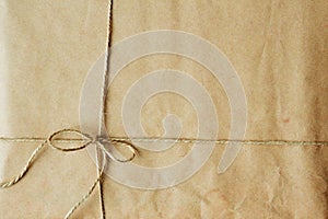 Overhead view of a single holiday package wrapped with eco friendly craft paper and tied with twine.