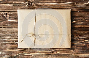 Overhead view of a single holiday package wrapped with eco friendly craft paper and tied with twine. Square format on a