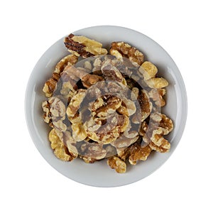Overhead view of a small white bowl filled with walnuts isolated on a white background