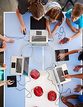 Overhead View Of Students In After School Computer Coding Class Learning To Program Robot Vehicle