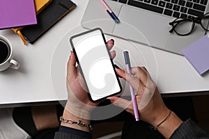 Stylish man hand using smart phone while sitting at creative workplace.