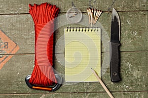 Overhead view of survival gear equipment to survive and Notebook