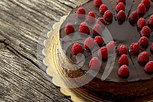 Overhead view of tasty raw chocolate cake decorated with raspber