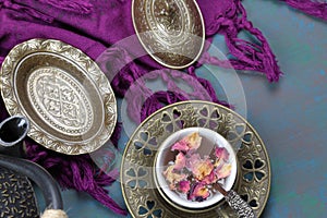 Overhead view of a tea cup of Rose tea with rose petals