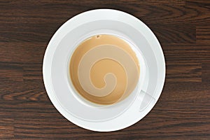 Overhead view of tea in a cup and saucer on wood