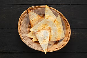 Overhead view of tortilla cut on triangular slices in wicker backet