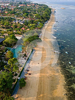 Overhead view of traditional boats moored off a tropical beach with fringing coral reef in Sanur