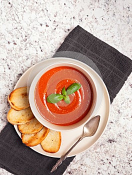 Overhead view of vegan tomato soup on a granite surface