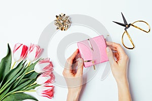 Overhead view woman's hands unpack gift box