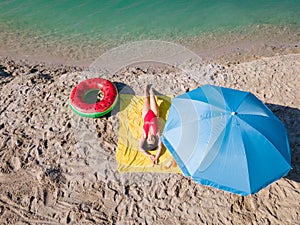 overhead view woman sunbathing at sandy beach