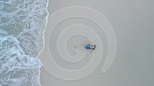 overhead view of woman in swimsuit at sea beach