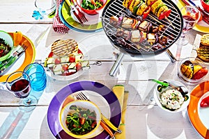 Overhead Well Laid summer table with colorful dish and brazier