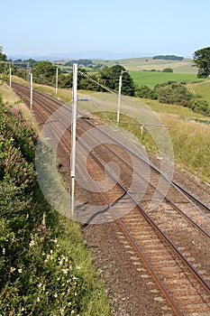 Overhead wires and railway track in countryside photo