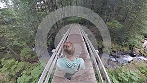 Overhead of woman hiking on wooden bridge