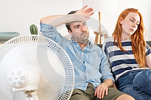 Young couple suffering summer heat wave at home