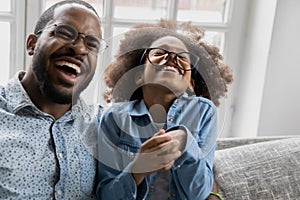 Overjoyed african american family in eyeglasses laughing at funny joke.