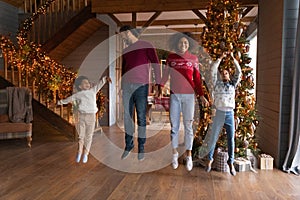 Overjoyed African American family jumping, enjoying winter holidays at home