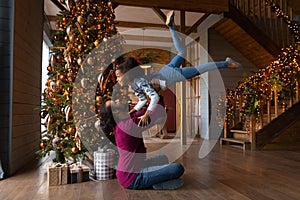 Overjoyed African American father playing with daughter on winter holiday