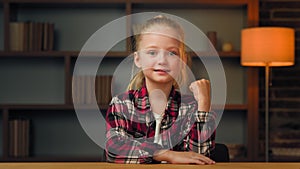 Overjoyed beautiful little young baby pupil in shirt posing clenching doing yes hand gesture. Girl wins competition