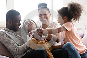 Overjoyed biracial family with kids have fun at home photo