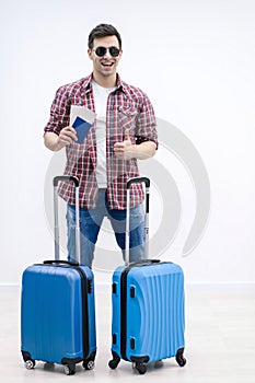 Overjoyed boy with suitcases and travel documents is eager to discover new destination and feelings.