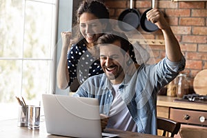 Overjoyed couple celebrate online win on laptop