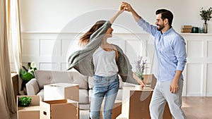 Overjoyed couple dance have fun on moving day